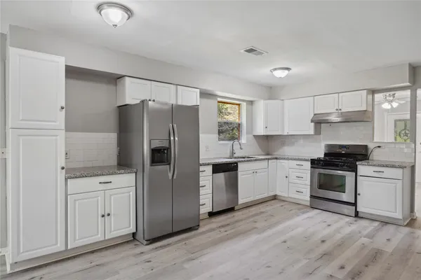 a kitchen with a refrigerator stove top oven and sink