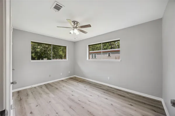 a view of empty room with wooden floor