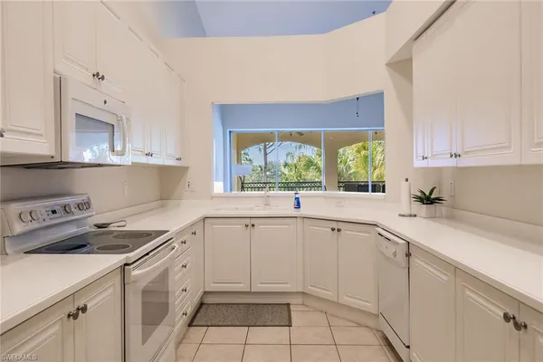 a kitchen with a white cabinets and white appliances