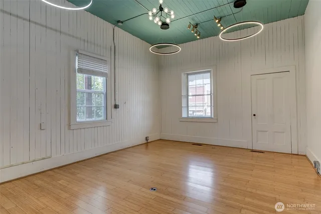 an empty room with wooden floor and mirror