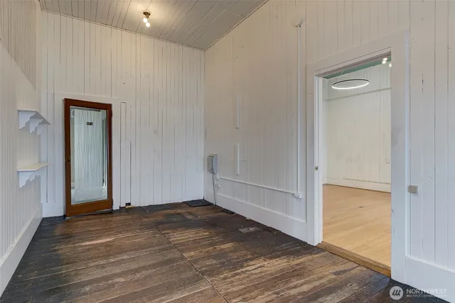 a view of an empty room with wooden floor and closet