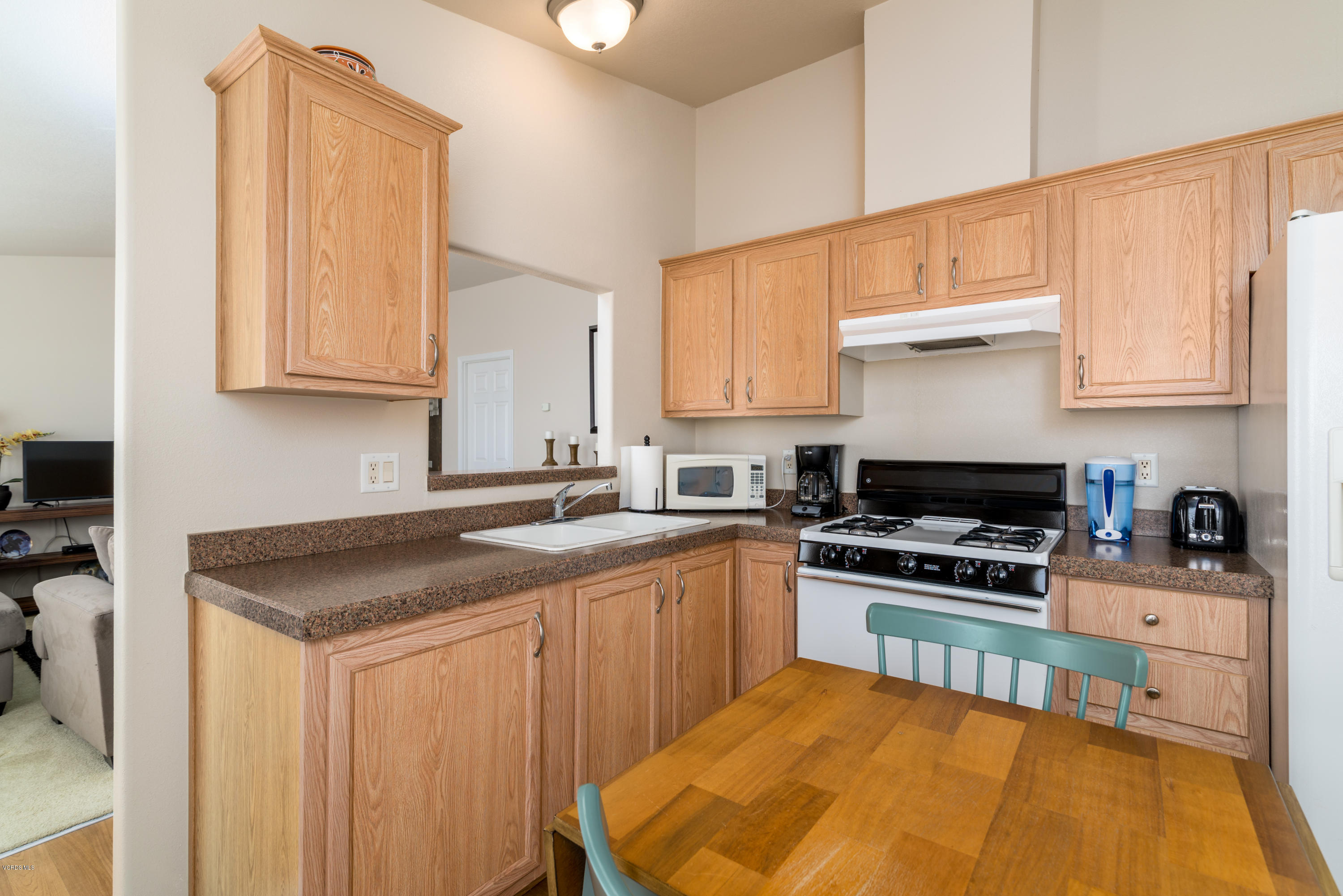 2132 Bluejay Avenue Oxnard, CA 93033 - Photo 5 of 20 a kitchen with stainless steel appliances granite countertop a stove a sink dishwasher and a refrigerator with wooden cabinets