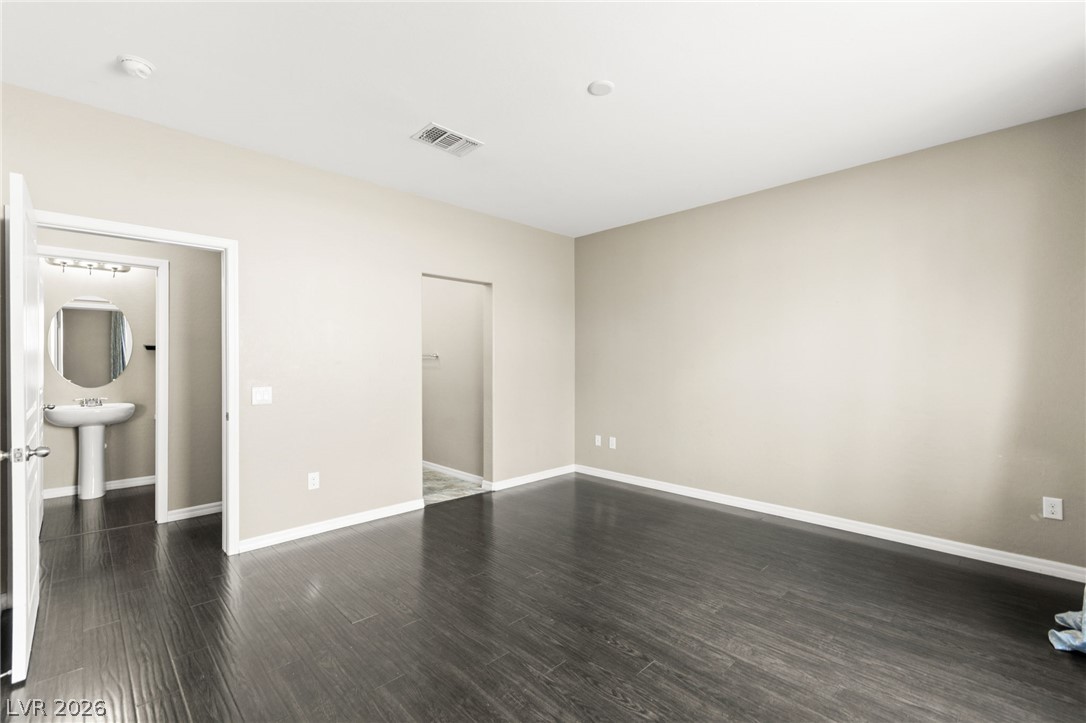 11048 Prairie Grove Road Las Vegas, NV 89179 - Photo 22 of 75 Rich dark wood flooring extends through this generously sized, naturally illuminated bedroom.