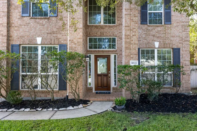a front view of a house with a yard and potted plants