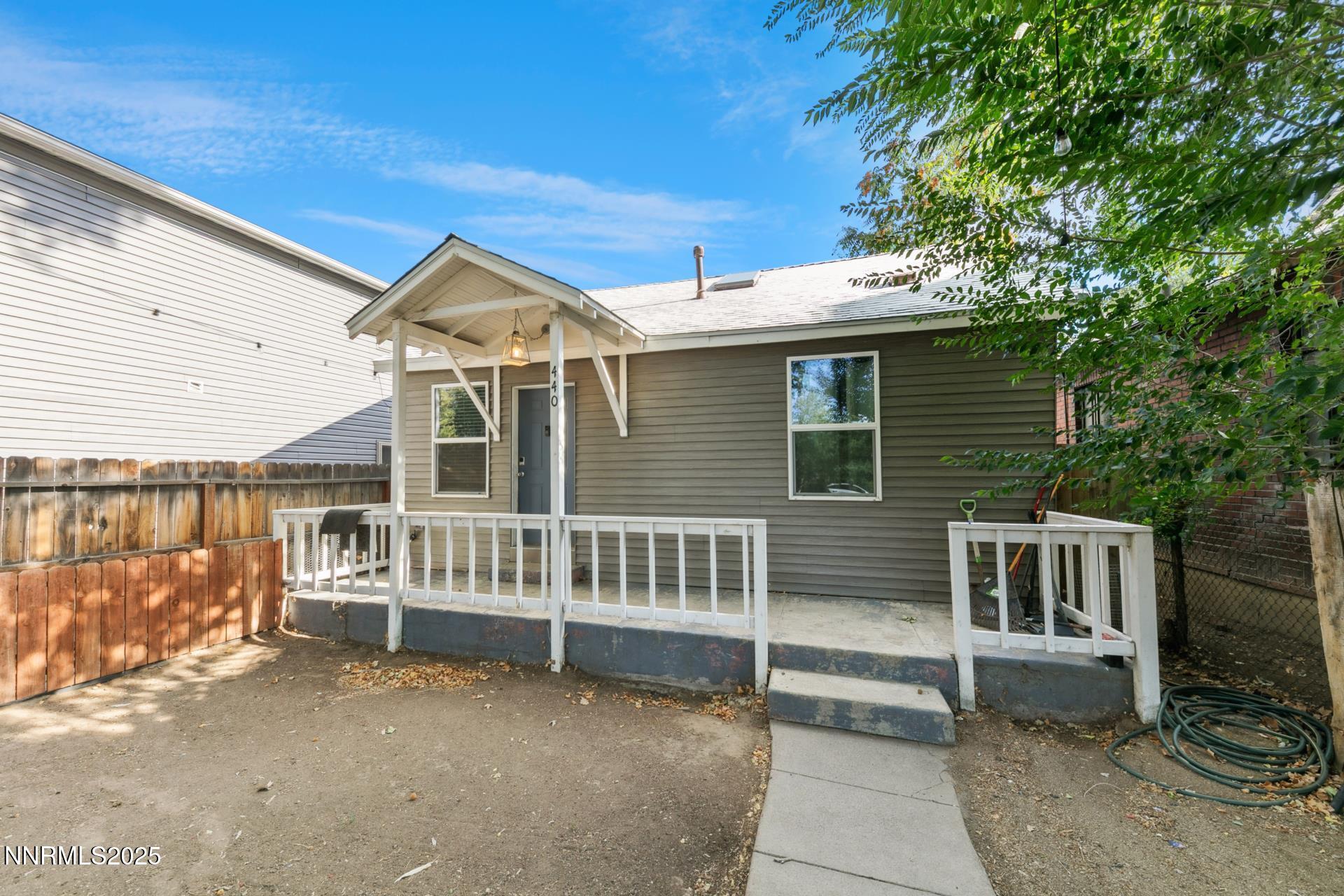 a view of a house with a wooden deck and a yard