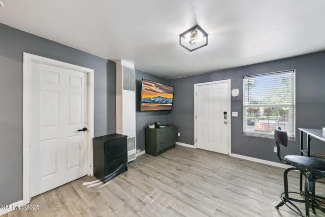 a bedroom with furniture wooden floor and window