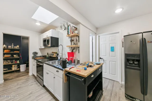 a kitchen that has a lot of cabinets a sink and appliances