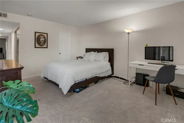 a bedroom with a bed chair and a television