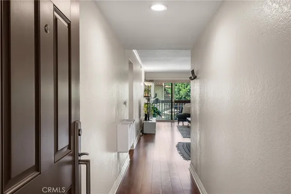 a view of a hallway with wooden floor and a living room