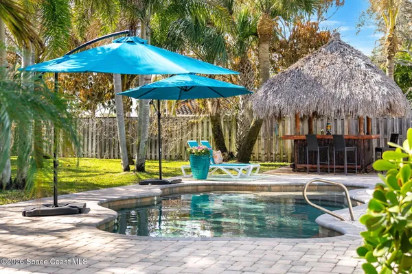 a view of a house with swimming pool and sitting area