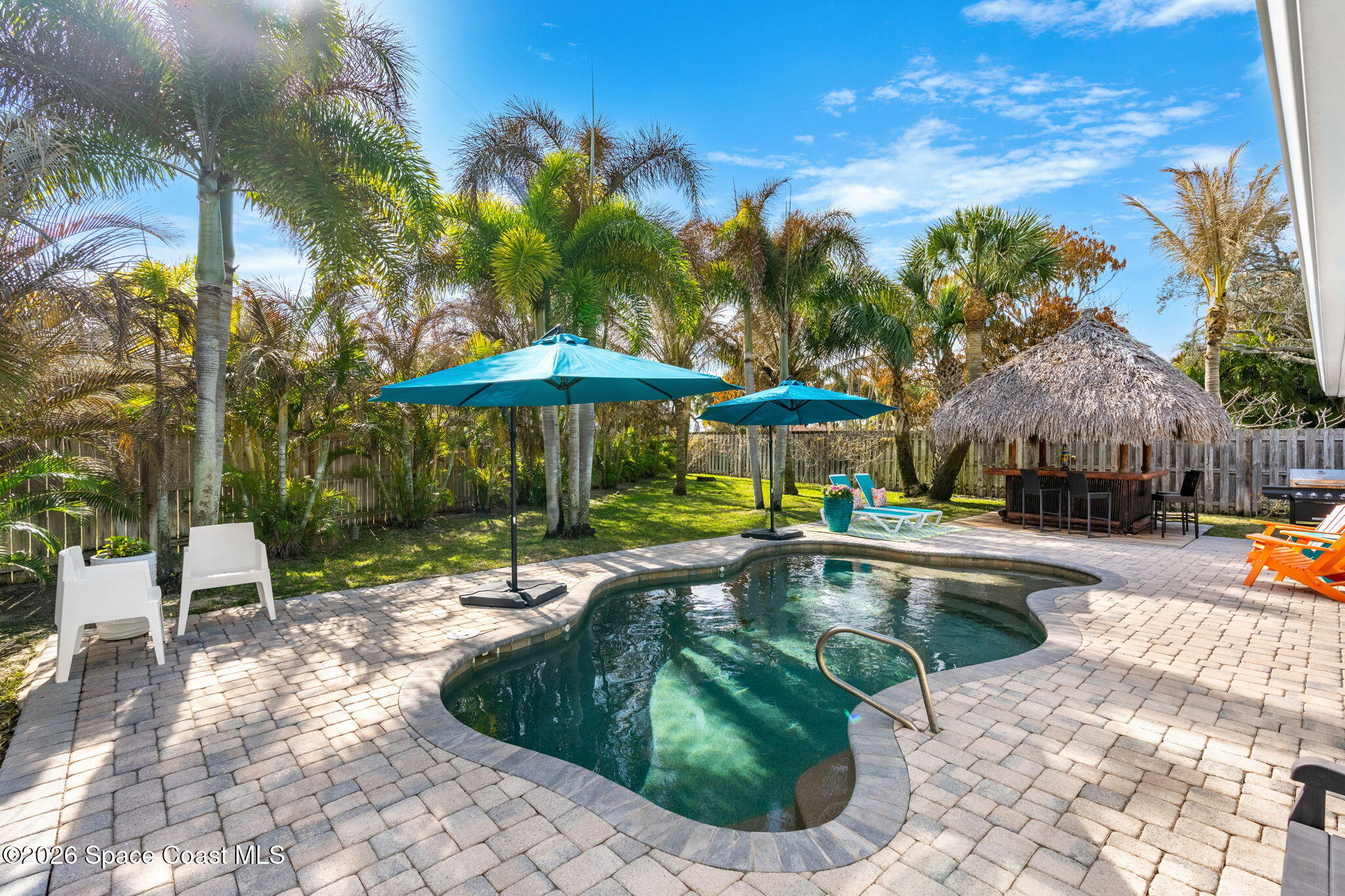 3 Jennifer Circle Indialantic, FL 32903 - Photo 44 of 61 a view of a swimming pool with a table and chairs under an umbrella