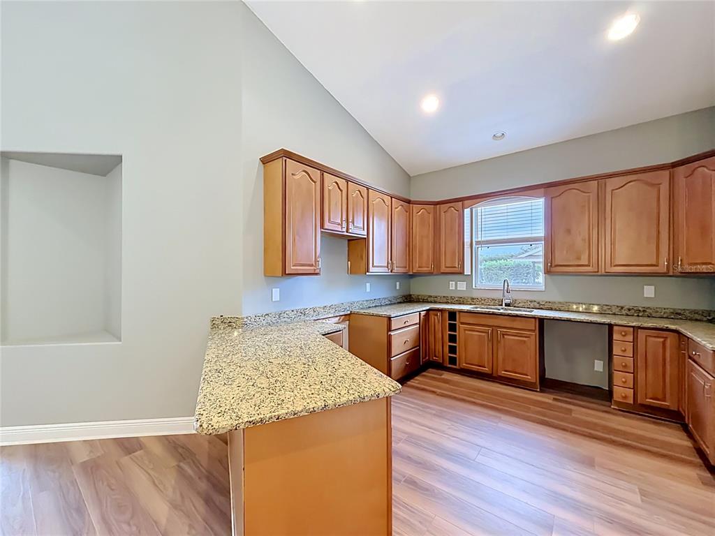 28549 Shirley Shores Road Tavares, FL 32778 - Photo 20 of 65 a kitchen with stainless steel appliances granite countertop wooden cabinets a stove a sink and dishwasher with wooden floor