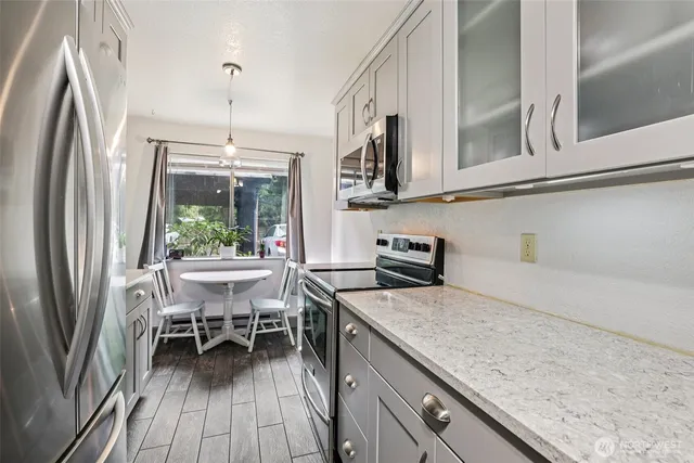 a kitchen with stainless steel appliances granite countertop a refrigerator and a stove top oven