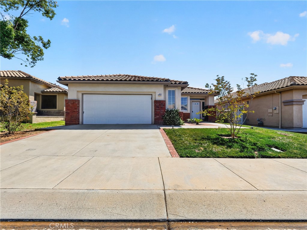 1436 Riviera Avenue Banning, CA 92220 - Photo 4 of 43 a front view of a house with a yard and garage