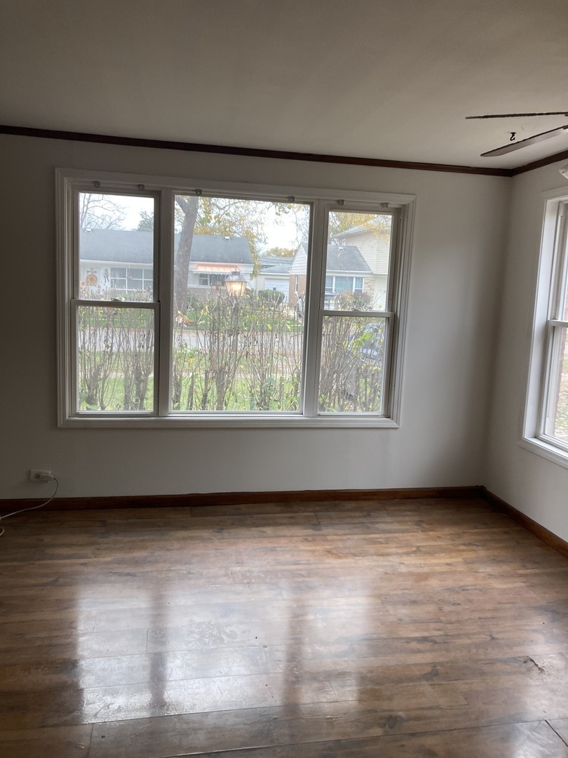 2155 Spruce Road Homewood, IL 60430 - Photo 3 of 18 a view of an empty room with wooden floor and a window