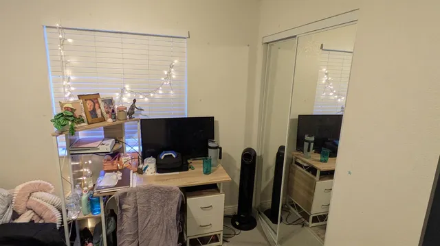 a view of a workspace with furniture and a window