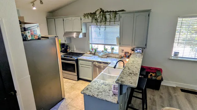 a kitchen with stainless steel appliances granite countertop a refrigerator and a stove