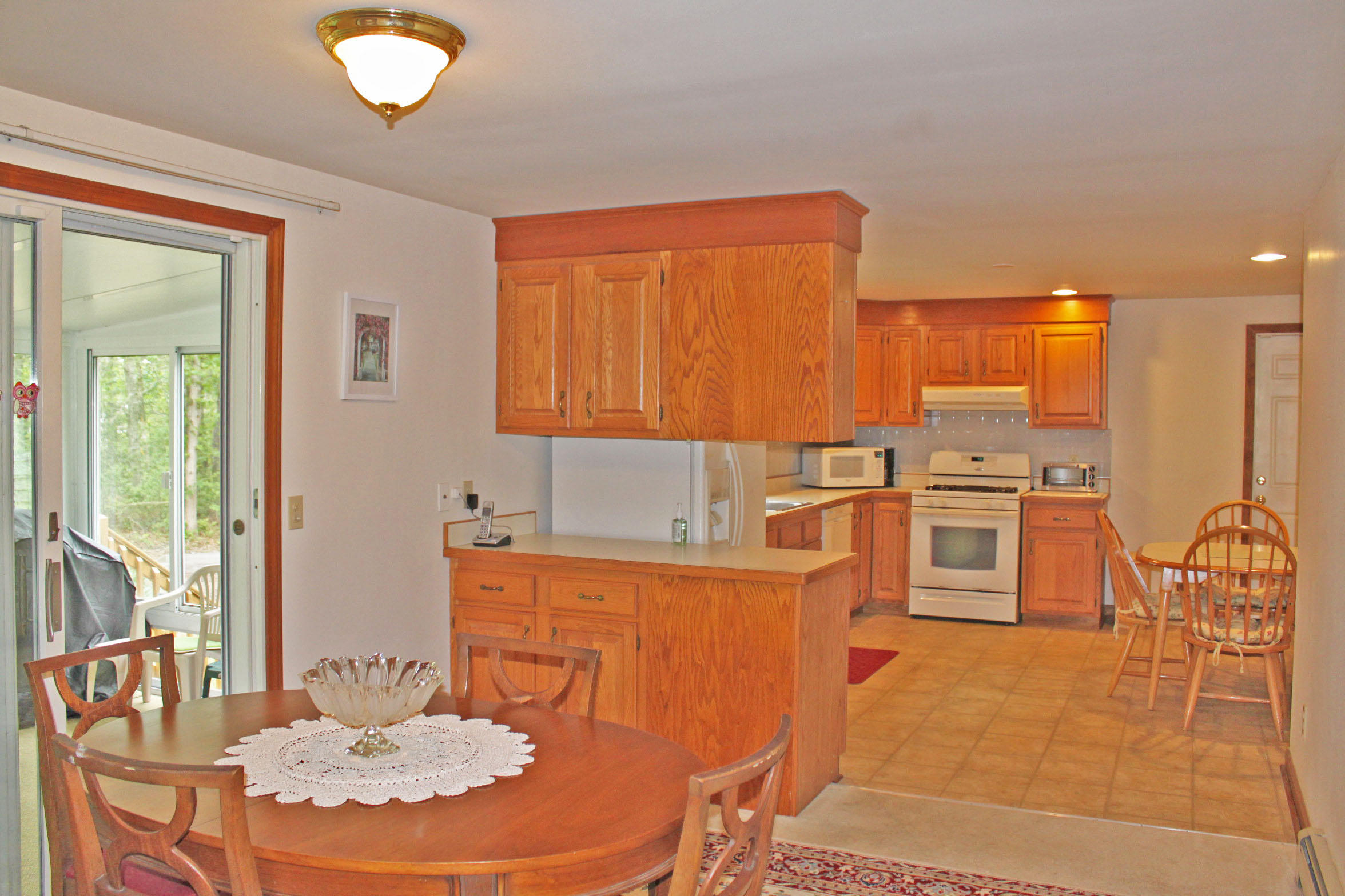 149 Camelback Road Marstons Mills, MA 02648 - Photo 3 of 25 a kitchen with stainless steel appliances wooden cabinets and a stove top oven