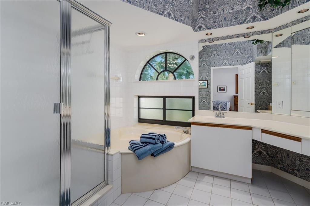 6545 Valen Way, Unit F205 Naples, FL 34108 - Photo 15 of 40 a bathroom with a sink a mirror and a bathtub