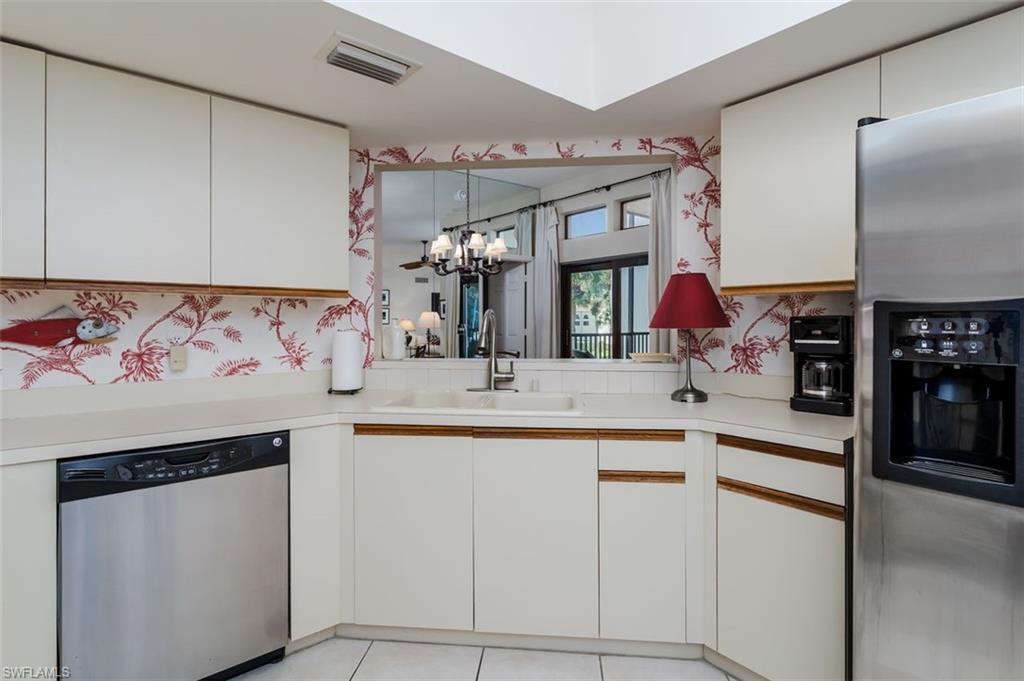 6545 Valen Way, Unit F205 Naples, FL 34108 - Photo 21 of 40 a kitchen with cabinets and chairs
