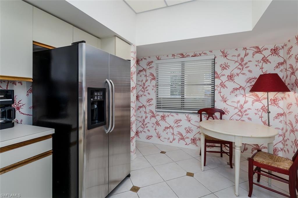 6545 Valen Way, Unit F205 Naples, FL 34108 - Photo 22 of 40 a kitchen with stainless steel appliances granite countertop a refrigerator and a stove top oven