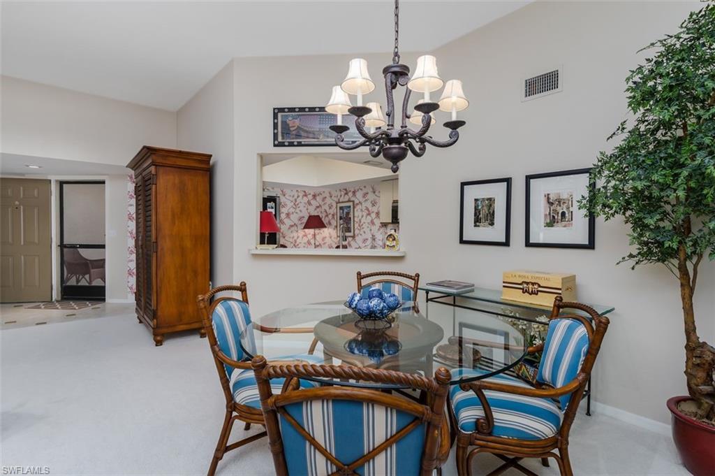 6545 Valen Way, Unit F205 Naples, FL 34108 - Photo 24 of 40 a dining room filled chandelier and wooden floor