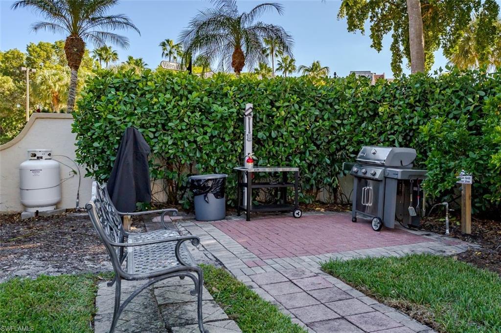6545 Valen Way, Unit F205 Naples, FL 34108 - Photo 26 of 40 a view of a chair and tables in the patio in front of the house