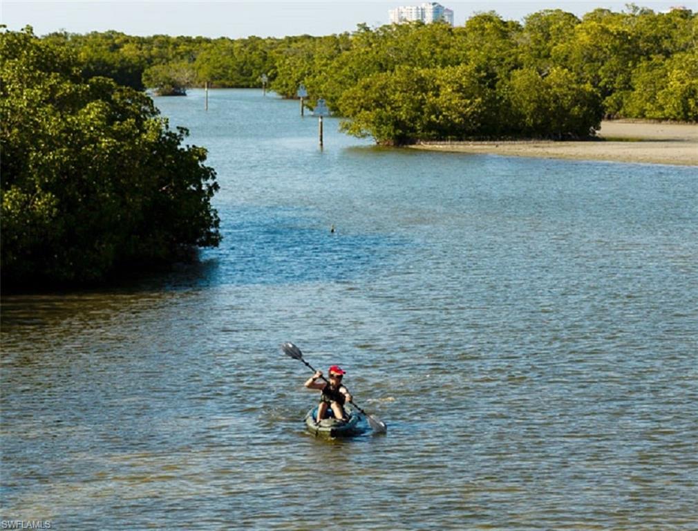 6545 Valen Way, Unit F205 Naples, FL 34108 - Photo 39 of 40 a man sitting on a bench in a field