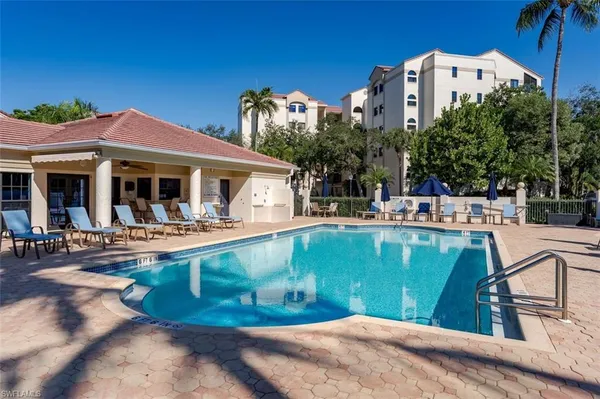 a view of a house with pool and chairs
