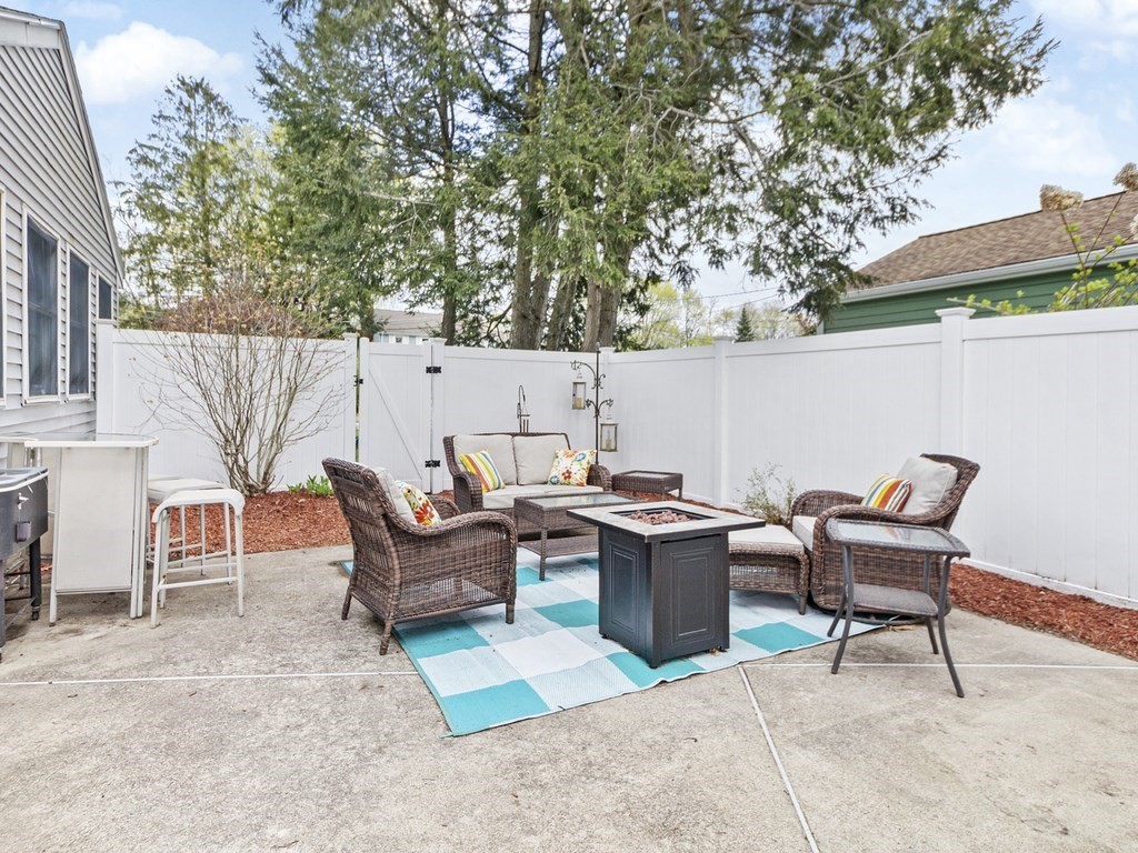 237 Linden Street Waltham, MA 02452 - Photo 30 of 33 a view of a patio with table and chairs with wooden fence