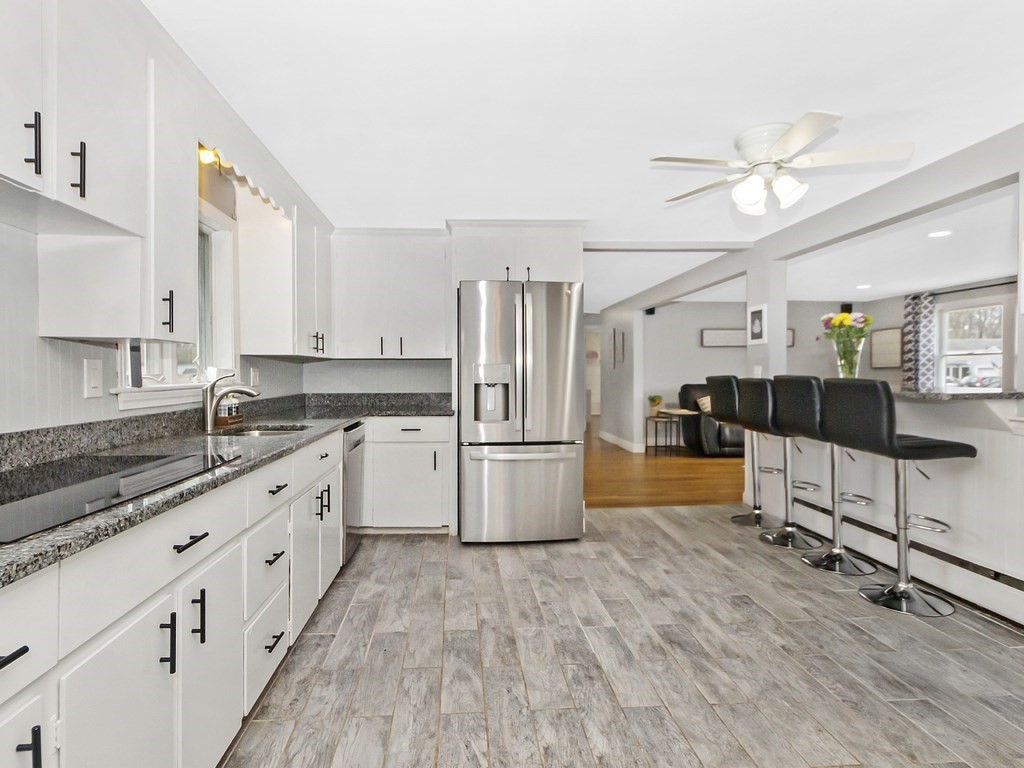 237 Linden Street Waltham, MA 02452 - Photo 5 of 33 a white kitchen with stainless steel appliances granite countertop a stove a sink dishwasher and a refrigerator with wooden floor