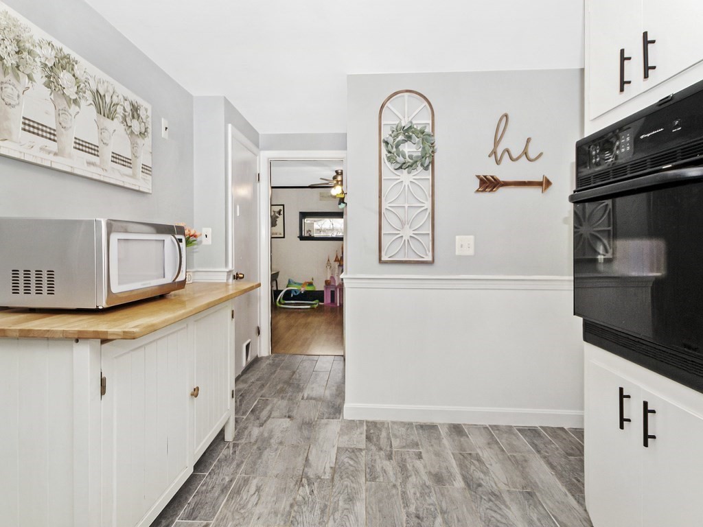 237 Linden Street Waltham, MA 02452 - Photo 6 of 33 a kitchen with granite countertop a refrigerator a stove and a sink with wooden floor