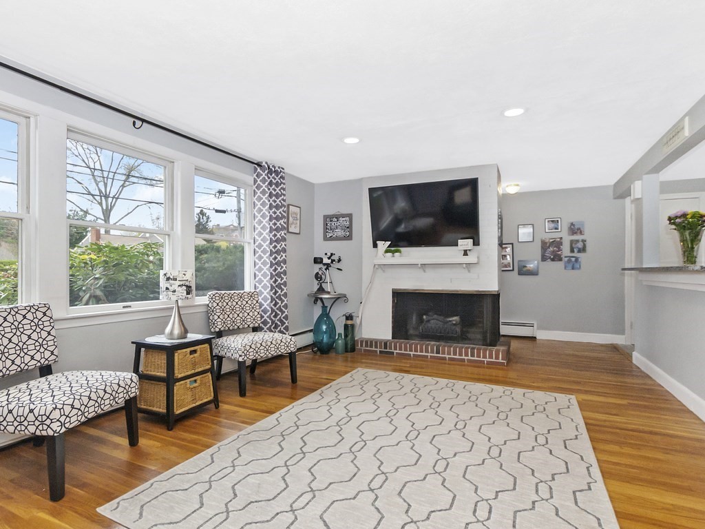 237 Linden Street Waltham, MA 02452 - Photo 8 of 33 a living room with furniture a flat screen tv and a fireplace