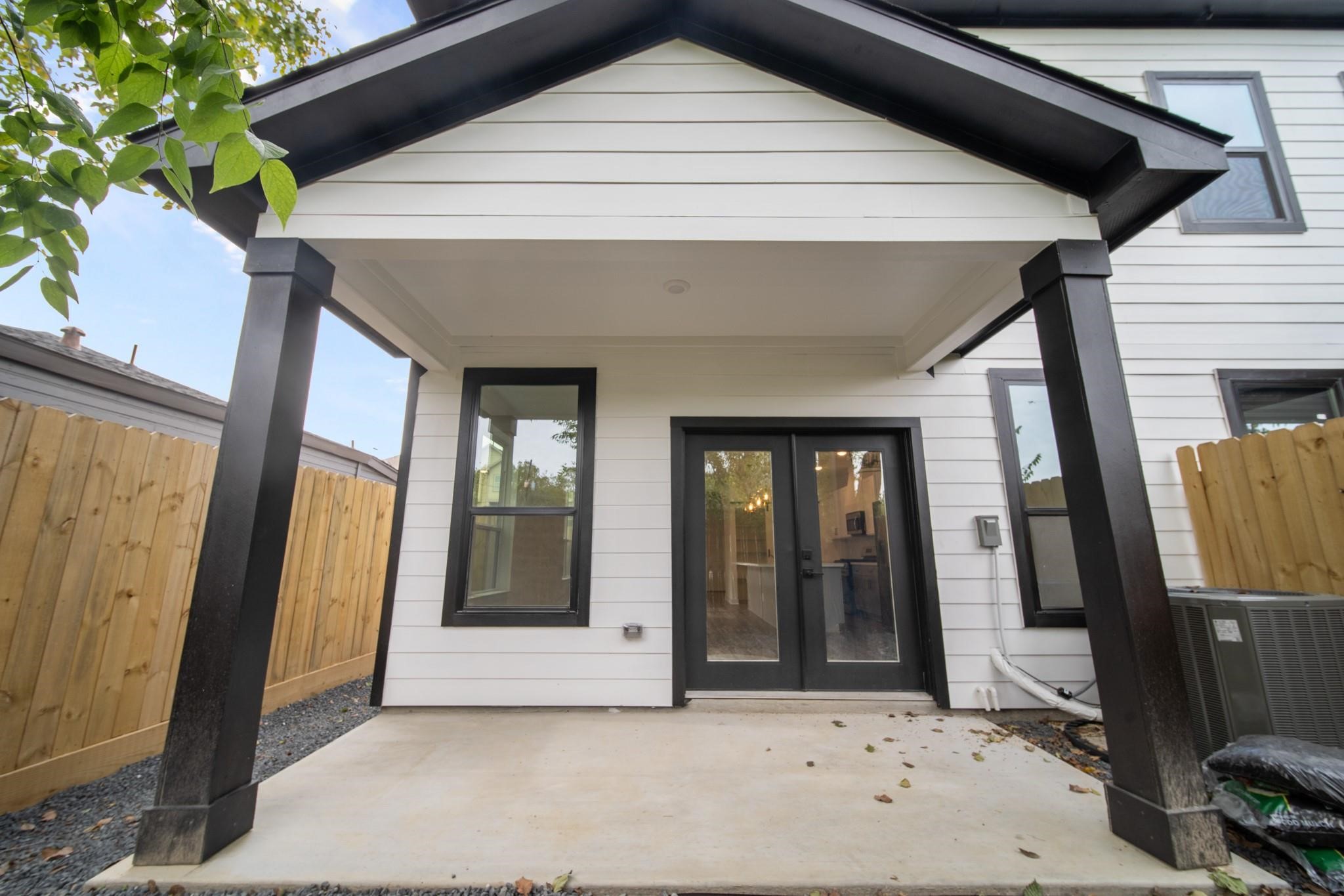 5813 England Street, Unit A Houston, TX 77021 - Photo 18 of 18 Charming covered patio with sleek black columns and double doors, perfect for outdoor relaxation and entertaining.