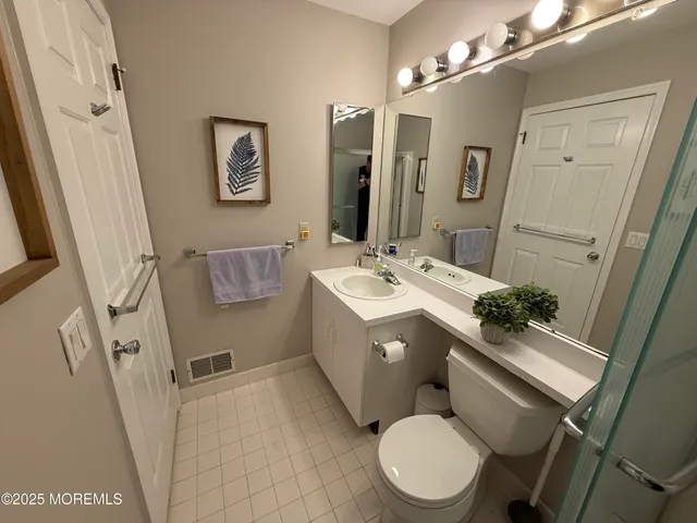 a bathroom with a sink mirror vanity and toilet