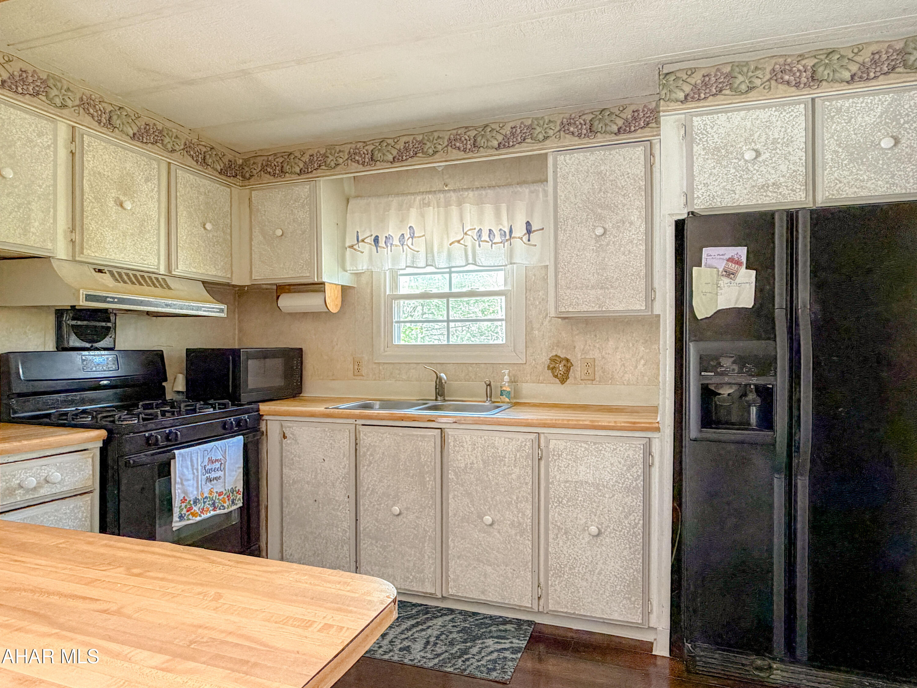 151 Pine Echo Road Everett, PA 15537 - Photo 20 of 51 a kitchen with stainless steel appliances granite countertop a refrigerator a sink dishwasher and white cabinets with wooden floor