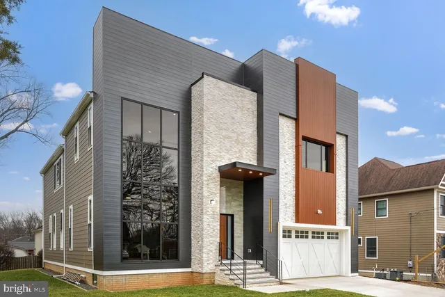a front view of a building with a garden and plants
