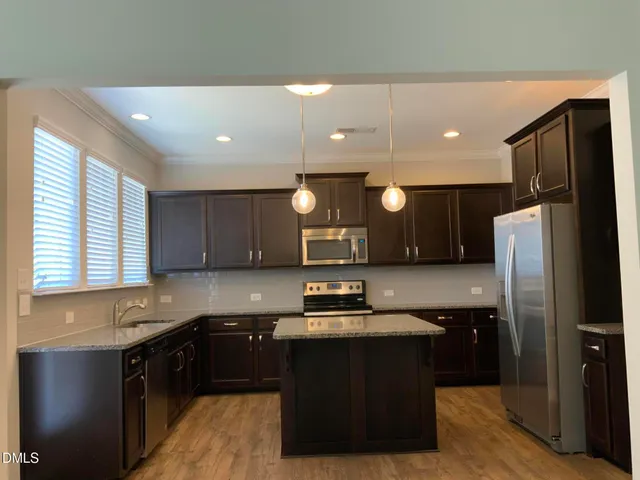 a kitchen with stainless steel appliances granite countertop a refrigerator and a sink