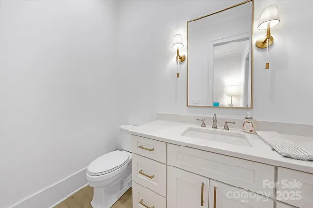 a bathroom with a toilet sink vanity and mirror