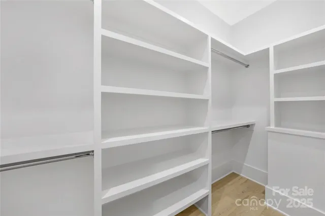 a view of walk in closet with empty racks