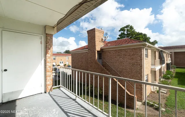 a view of a balcony with wooden floor and fence