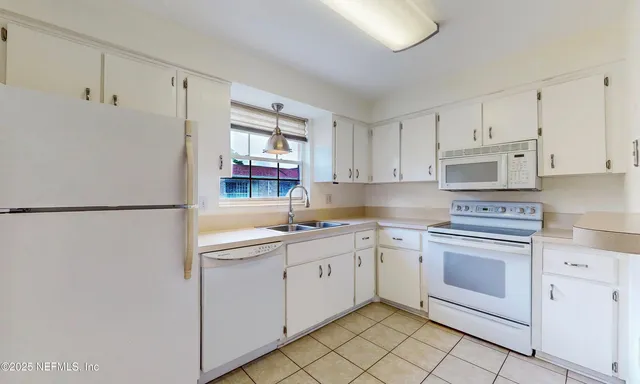 a kitchen with white cabinets and white appliances