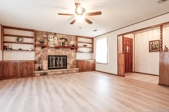 wooden floor fireplace and windows in an empty room