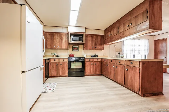 a kitchen with stainless steel appliances granite countertop a stove sink and cabinets