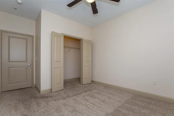 an empty room with a window and a ceiling fan