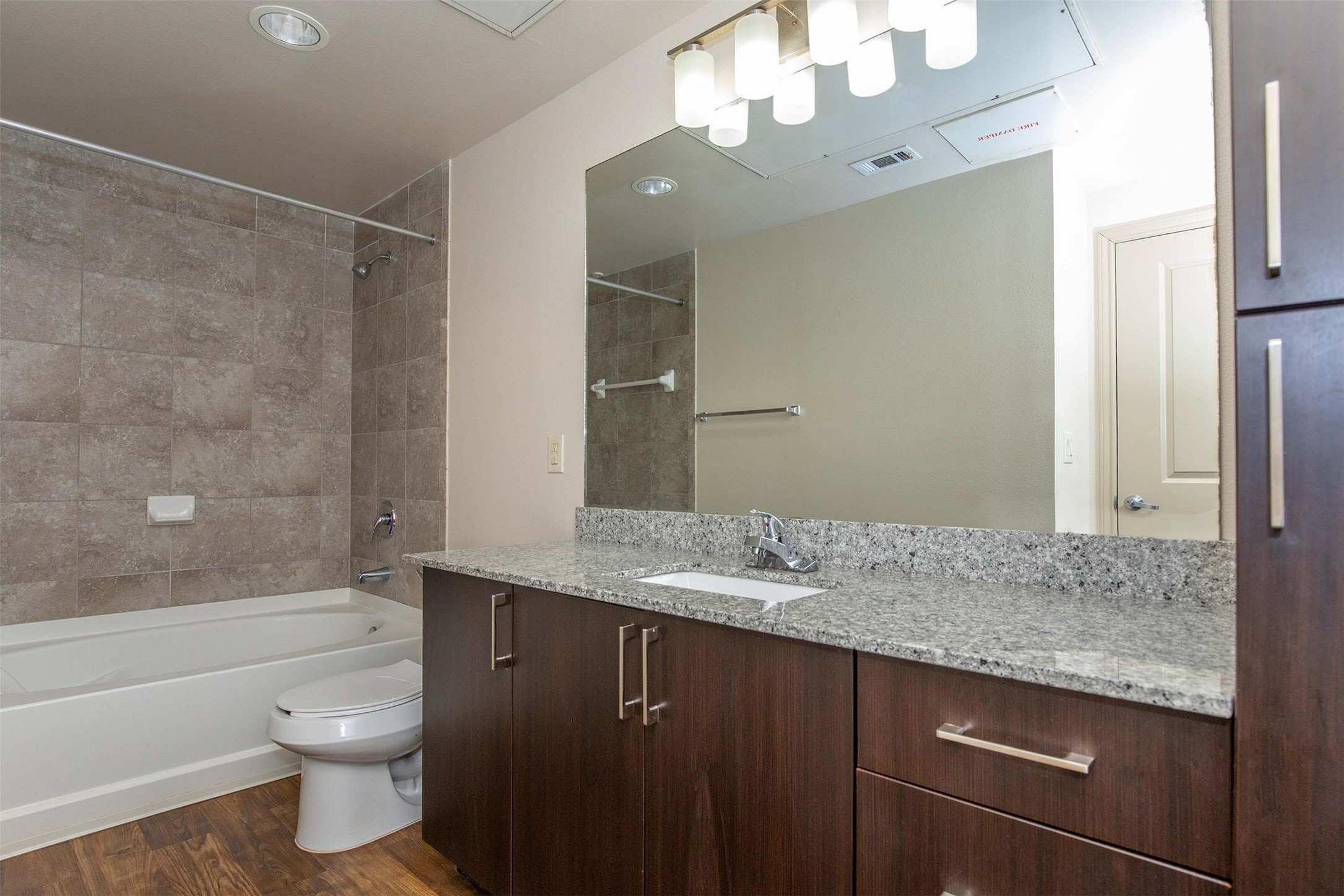 2930 Plum Creek Lane, Unit 2102 Houston, TX 77087 - Photo 9 of 19 a bathroom with a granite countertop sink toilet a large mirror a bathtub and shower