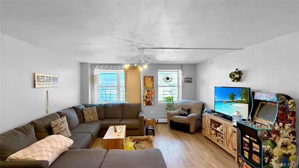 a living room with furniture a flat screen tv and a window