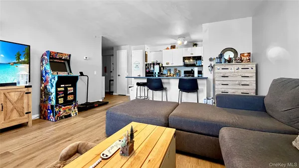 a living room with furniture a flat screen tv and gym equipment