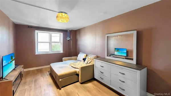a view of an empty room with closet and wooden floor