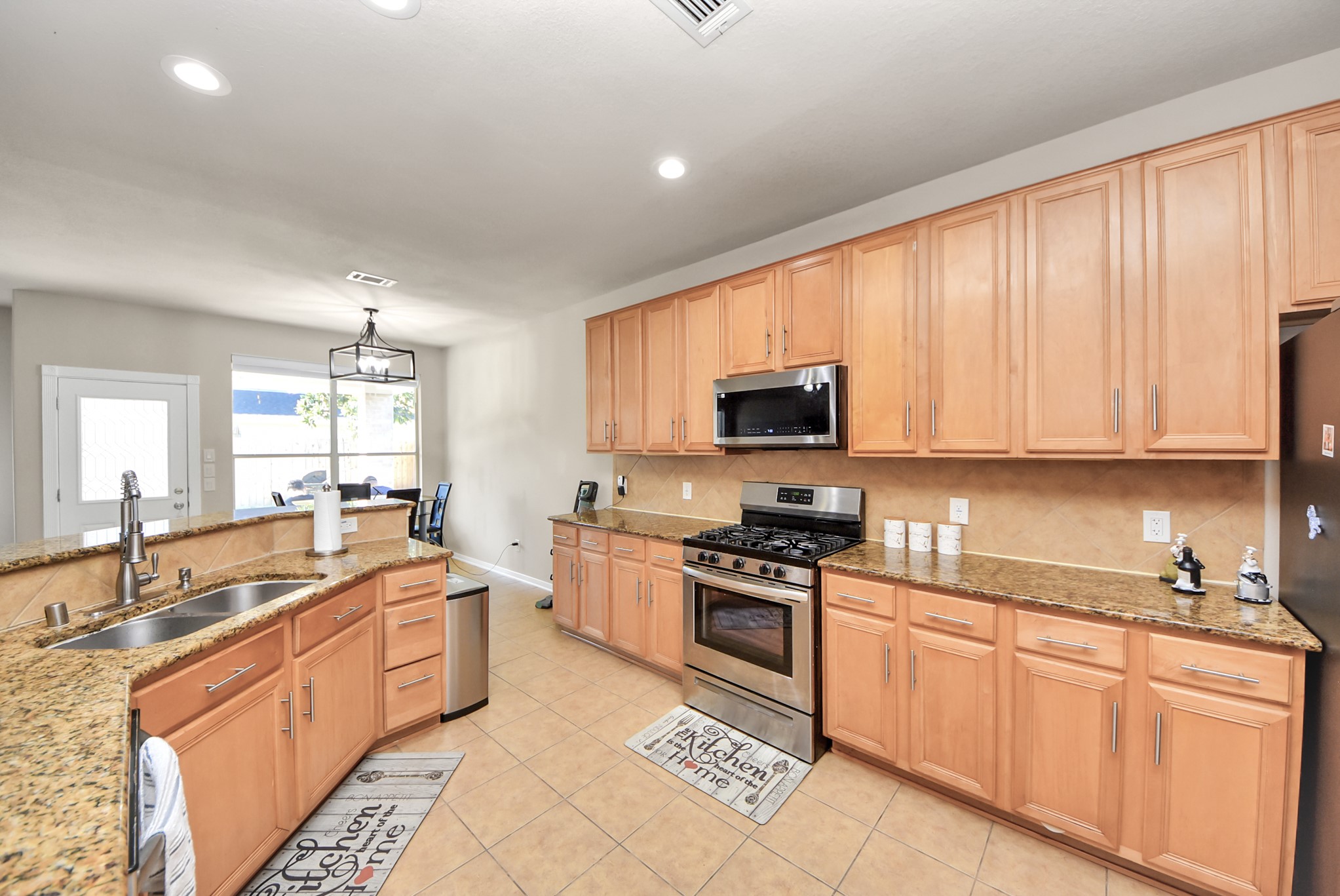18715 Keystone Oak Street Houston, TX 77084 - Photo 16 of 50 a large kitchen with stainless steel appliances granite countertop a stove sink and cabinets